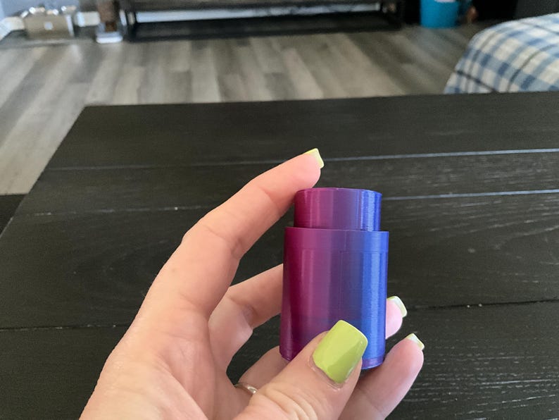 Puede incluir: Un tap&oacute;n de botella morado y azul con un acabado liso y brillante.