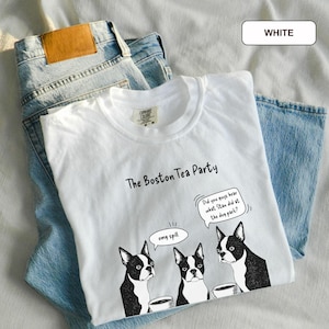 May include: White t-shirt with a graphic of three Boston Terriers and the text "The Boston Tea Party." One dog has a speech bubble that says "omg spill." Another speech bubble says "Did you guys hear what Stan did at the dog park?"
