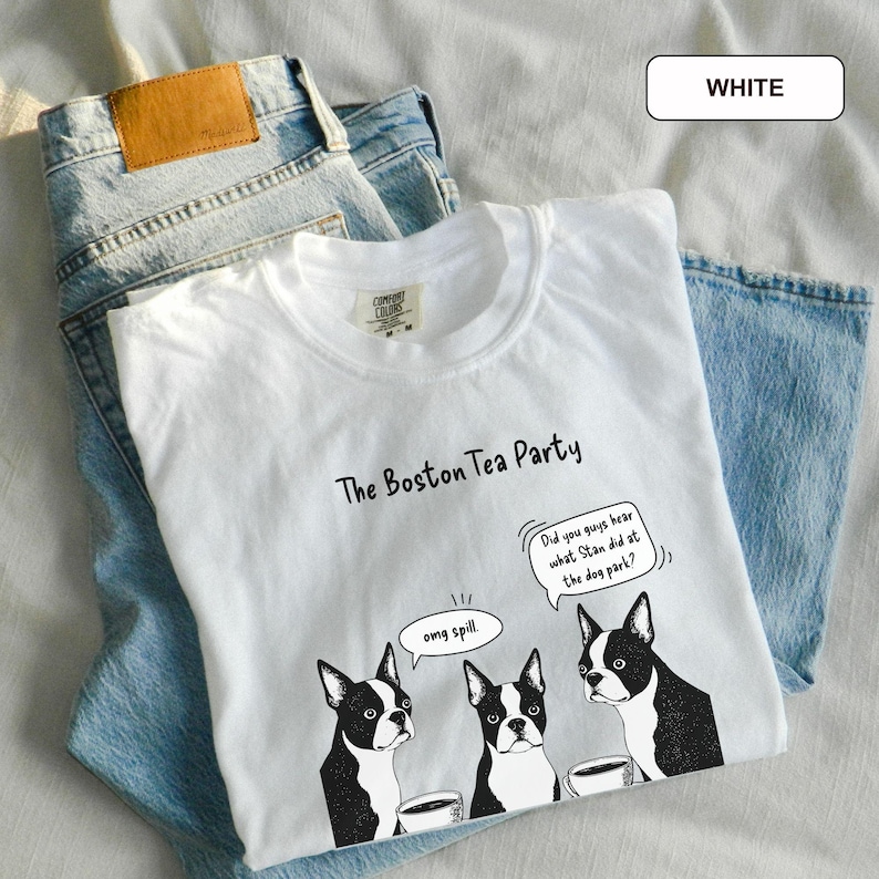 May include: White t-shirt with a graphic of three Boston Terriers and the text "The Boston Tea Party." One dog has a speech bubble that says "omg spill." Another speech bubble says "Did you guys hear what Stan did at the dog park?"