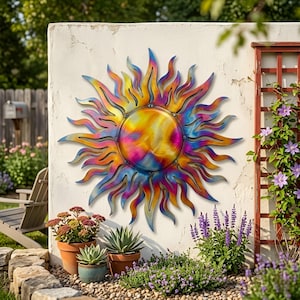Pu&ograve; includere: Una grande opera d'arte murale in metallo a forma di sole. Il sole ha un design vibrante e vorticoso con sfumature di giallo, arancione, rosa e blu. Il sole &egrave; montato su un muro bianco, con piante e fiori in primo piano.