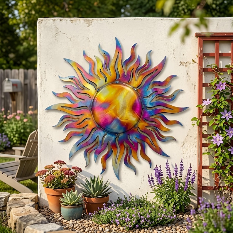 Pu&ograve; includere: Una grande opera d'arte murale in metallo a forma di sole. Il sole ha un design vibrante e vorticoso con sfumature di giallo, arancione, rosa e blu. Il sole &egrave; montato su un muro bianco, con piante e fiori in primo piano.