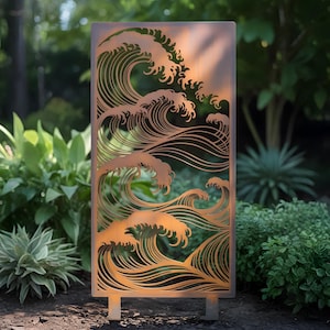 May include: A rectangular, bronze-colored metal garden screen featuring a cut-out design of stylized ocean waves. The screen stands upright with two small feet, set against a backdrop of green foliage and natural light.