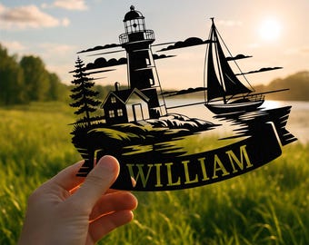 Può includere: Opera d'arte in metallo nero raffigurante un faro, una barca a vela e una casa su una riva rocciosa. Il nome "WILLIAM" è visualizzato su uno striscione sottostante. L'opera è tenuta contro uno sfondo di un campo erboso e un tramonto.
