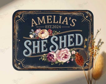 May include: A rectangular, navy blue metal sign with the words "AMELIA'S SHE SHED EST.2024" in white and light blue lettering. The sign is decorated with floral accents in pink, purple, and cream colors. The sign has a distressed, vintage look.