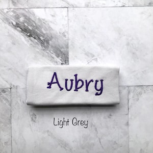Personalized light grey handle wrap, with purple embroidery your choice of name or monogram. Our handle wraps measure  4.5 inches by 5.25 inches and are 100% cotton with a strip of Velcro to attach securely around any handle.
