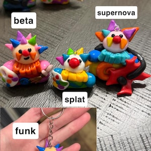 May include: A collection of colourful clown figurines and keychains featuring the labels beta, supernova, splat, and funk. The figures have spiked hair, red noses, and various accessories like paint palettes and guitars, with text reading PUNK ROCK / artist clowns.