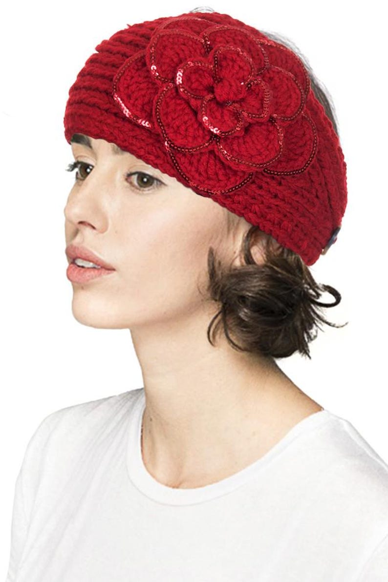 K&ouml;nnte beinhalten: Ein rotes Stirnband aus Strick mit einer gro&szlig;en, mit Pailletten besetzten Blume. Das Stirnband ist aus einem dicken, strukturierten Garn gefertigt und wird auf dem Kopf getragen. Die Blume ist das zentrale Dekorationselement.