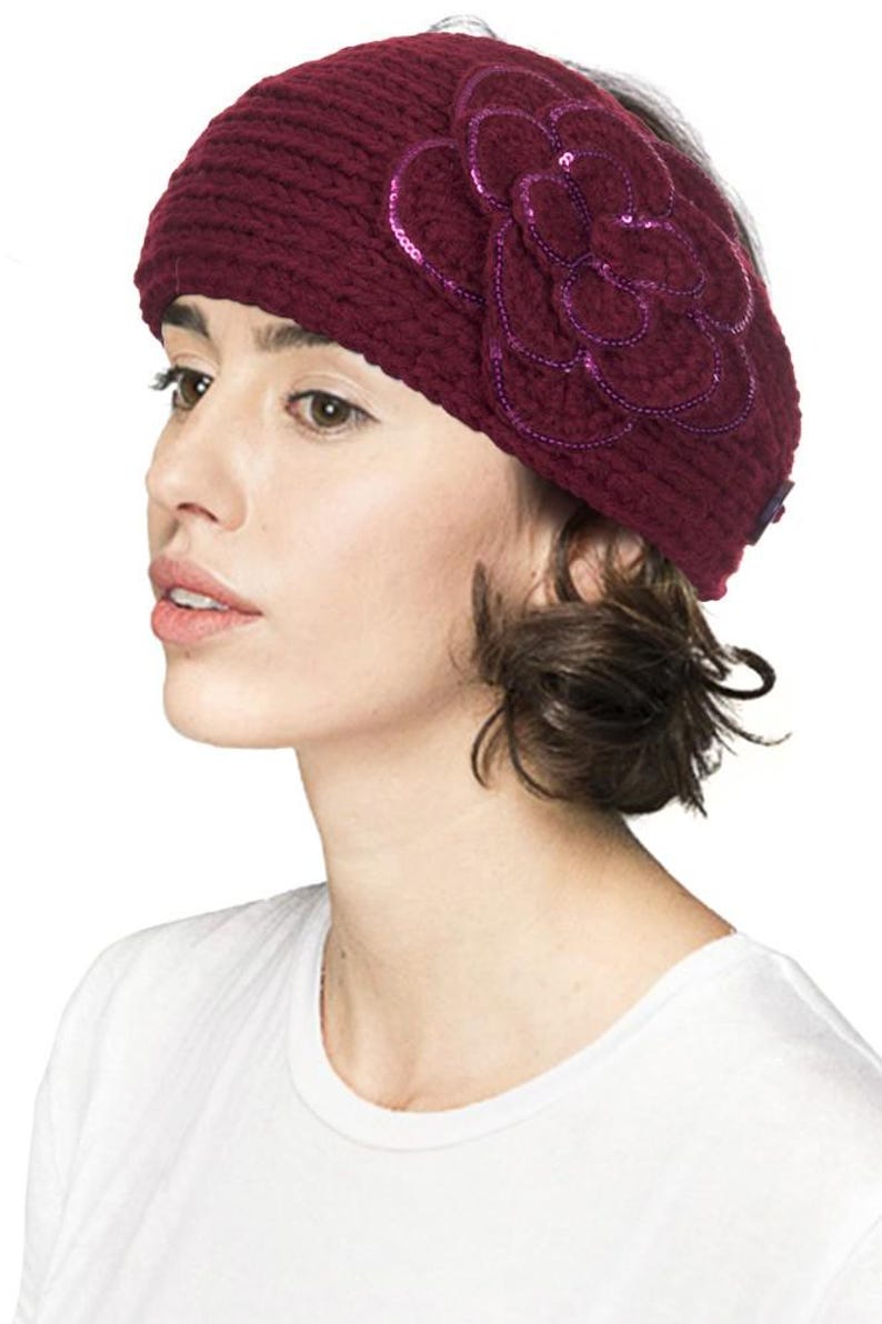 K&ouml;nnte beinhalten: Ein weiches, weinrotes Stirnband mit einer gro&szlig;en, paillettenbesetzten Blume. Die Blume hat geschichtete Bl&uuml;tenbl&auml;tter und eine dunkelviolette Umrandung. Das Stirnband wird von einer Person getragen, die ein wei&szlig;es T-Shirt tr&auml;gt.