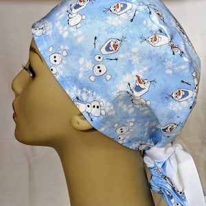 May include: A blue surgical scrub hat with a white tie. The hat has a repeating pattern of Olaf from the movie Frozen.