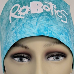 May include: A turquoise blue scrub hat with a white tie-dye pattern and the word "Robotics" in white lettering with a gear symbol.