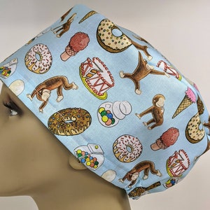 May include: A blue and white patterned scrub hat with a monkey, donut, ice cream cone, and gumball machine design.