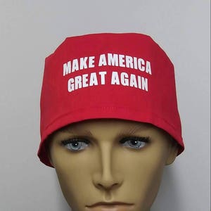 May include: Red surgical scrub hat with the text "Make America Great Again" in white.