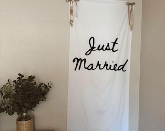 Pancarta de boda de tela pintada a mano con la frase "Recién casados"
