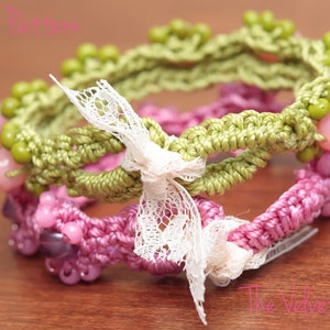 May include: Two crocheted bracelets with beads and a white lace bow. The top bracelet is green with light green beads and the bottom bracelet is pink with purple and pink beads.