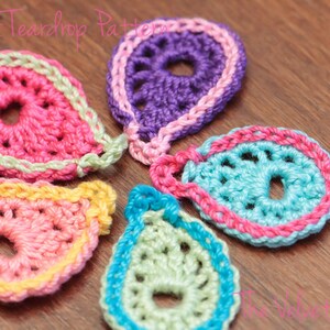 Peut inclure: Cinq formes de larmes en crochet de diff&eacute;rentes couleurs, dont le rose, le violet, le bleu, le vert et le jaune. Chaque larme a un petit cercle au centre.