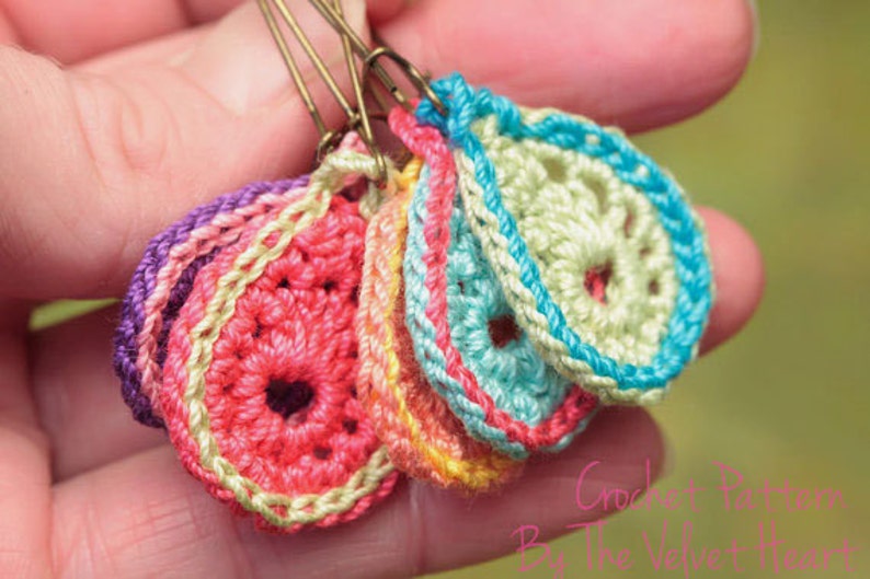 Peut inclure: Un ensemble de cinq marqueurs de points de crochet en forme de fleur dans diff&eacute;rentes couleurs, notamment rose, violet, bleu, vert et jaune. Les marqueurs de points sont attach&eacute;s &agrave; des &eacute;pingles de s&ucirc;ret&eacute;.