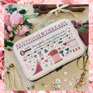 Może przedstawiać: Wyszywana krzyżykami kosmetyczka z napisem "NOTIONS & THREADS" i "She seeketh wool, and flax, and worketh willingly with her hands." Etui zawiera obrazy nożyczek, szpulek i guzików. Różowe róże i perły otaczają etui.