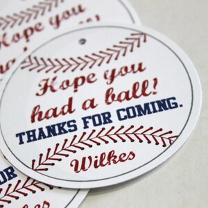 Peut inclure: Etiquettes rondes blanches avec des coutures de baseball rouges et bleues et du texte. Le texte dit "J'esp&egrave;re que vous avez pass&eacute; un bon moment ! Merci d'&ecirc;tre venu. Wilkes".