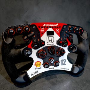 May include: A white ceramic mug with a black handle and the text "But First, Coffee" in a black, handwritten-style font. The mug is on a white surface.