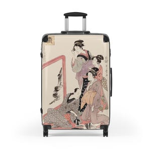 Puede incluir: Una maleta con ruedas que presenta un estampado de arte japonés con tres figuras en vestimenta tradicional. Una figura está sentada en el suelo con un pincel, mientras otras dos están de pie. El diseño incluye texto negro y un marco rojo.