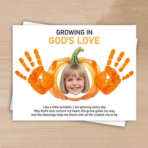 Peut inclure: Une carte rectangulaire avec le texte GROWING IN GOD'S LOVE en haut. Au centre, une illustration de citrouille orange avec le visage d'un enfant au milieu, entourée de deux empreintes de mains orange. En bas, le texte : Like a little pumpkin, I am growing every day. May God's love nurture my heart, His grace guide my way, and His blessings help me bloom into all He created me to be.