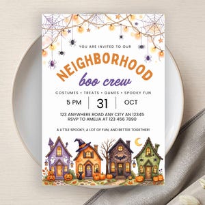 Könnte beinhalten: Eine rechteckige Halloween-Einladungskarte mit einer Lichterkette, Spinnweben und Spinnen am oberen Rand. Der Text lautet: YOU ARE INVITED TO OUR NEIGHBORHOOD boo crew. Darunter befinden sich vier illustrierte Häuser mit Kürbissen und Geistern.