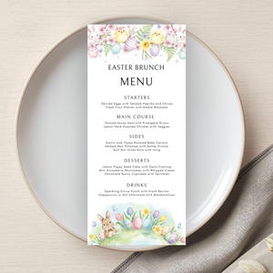 May include: A vertical Easter Brunch menu card with floral and Easter egg illustrations. The menu includes starters, main course, sides, desserts, and drinks. The menu is on a white plate with a gray napkin.