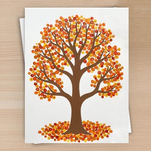 May include: A white paper print featuring a brown tree trunk and branches with a canopy of circular dots in shades of orange, yellow, and red. A collection of matching orange, yellow, and red circular dots is scattered at the base of the tree.