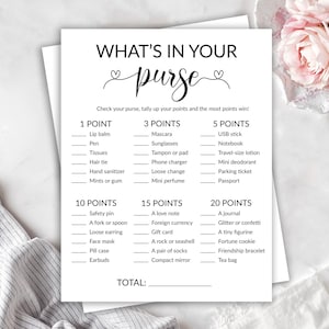 May include: A white card game titled "What's in Your Purse?" with a list of items and point values. The card includes categories like lip balm, mascara, and a journal. The card is on a white surface.