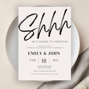 Puede incluir: Una tarjeta de invitación de color crema con texto negro. La palabra "Shhh" está escrita en una fuente grande y en negrita. La invitación es para una fiesta de compromiso sorpresa, con los nombres Emily & John.