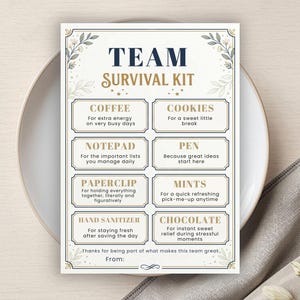 以下が含まれることがあります： TEAM SURVIVAL KITというタイトルの、濃紺と金色の文字が書かれた長方形の白いカード。コーヒー、クッキー、メモ帳、ペン、ペーパークリップ、ミント、ハンドサニタイザー、チョコレートなどのアイテムと、それぞれの説明が記載されており、植物の縁取りが施されています。
