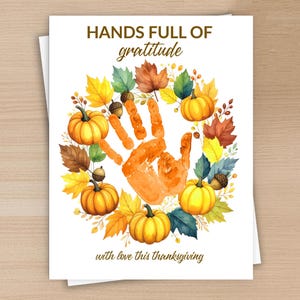 Könnte beinhalten: Dankeskartenmotiv mit einem Handabdruck, umgeben von Kürbissen, Blättern und Eicheln. Der Text lautet "HANDS FULL OF gratitude" und "with love this thanksgiving". Das Design zeigt Illustrationen im Aquarellstil.