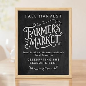 Peut inclure: Un panneau rectangulaire en ardoise avec un cadre en bois clair, affichant le texte blanc FALL HARVEST FARMERS MARKET, Fresh Produce, Homemade Goods, Local Favorites, et CELEBRATING THE SEASON'S BEST, orné de motifs décoratifs en lignes blanches.