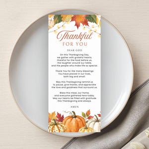 May include: A rectangular card featuring a Thanksgiving prayer titled Thankful For You. The design includes watercolor autumn leaves and string lights at the top, and a cluster of orange and white pumpkins at the bottom, printed on white paper.