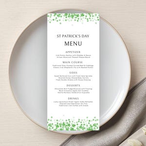 May include: A St. Patrick's Day menu card with a white background, featuring green shamrock accents at the top and bottom. The menu is displayed on a white plate, with a gray napkin on the side.