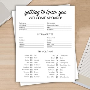 Puede incluir: Hoja de papel blanca con el texto "getting to know you WELCOME ABOARD!" y secciones para rellenar con información personal, favoritos y preguntas "Esto o aquello". Un portátil y un bloc de notas están en el fondo.