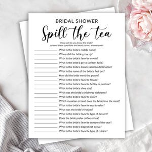 May include: A white bridal shower game sheet with the text "Spill the Tea" in elegant script. The game includes questions about the bride's preferences and life, perfect for a fun bridal shower activity.