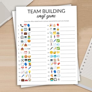 Może przedstawiać: Biała kartka zatytułowana "TEAM BUILDING emoji game" z zagadkami opartymi na emoji. Gra polega na odgadnięciu słów lub wyrażeń związanych z biurem. W tle widoczny jest laptop i notatnik.
