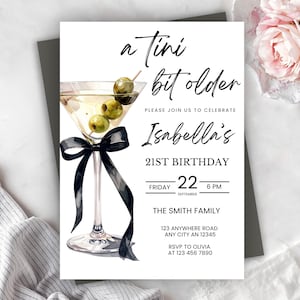 Könnte beinhalten: Eine weiße Einladungskarte mit einer Martini-Glas-Illustration, Oliven und einer schwarzen Schleife. Der Text lautet "a tini bit older" und kündigt Isabellas 21. Geburtstag am Freitag, den 22. September an. Enthält RSVP-Informationen.
