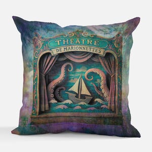 Könnte beinhalten: Dekoratives Kissen mit einer skurrilen Theaterszene. Das Design zeigt ein Segelboot auf welligem Wasser, einen Oktopus und den Text "THEATRE DE MARIONNETTES" im Vintage-Stil. Die Farbpalette umfasst Türkis, Lila und Braun.