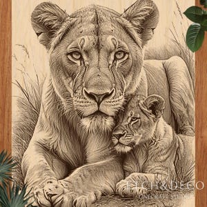 May include: A detailed wood-burned artwork shows a lioness and her cub. The lioness, with a focused gaze, is in the foreground, while the cub rests beside her. The artwork is set against tall grass, with the text "ETCH & DECO" visible.