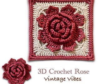 May include: A square, crocheted piece featuring a 3D rose in shades of red and cream. The rose is centered on a cream-colored background, framed by a red border. A smaller, detached rose is also present. Text reads "3D Crochet Rose Vintage vibes."