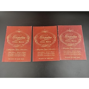 May include: Three vintage Metropolitan Opera House programs. Each program has a red cover with gold lettering and design. The programs are for the seasons of 1938-1939, 1940-1941, and 1941-1942.