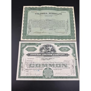 May include: Two vintage stock certificates. The top certificate is for the Colombia Syndicate, with green borders and text. The bottom certificate is for the Grigsby-Grunow Company, also with green borders and text. Both are on a black background.