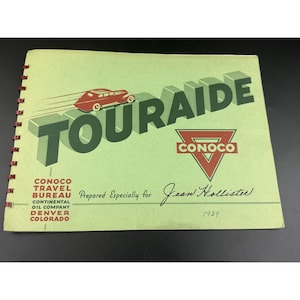 May include: A 1939 spiral-bound travel booklet titled TOURAIDE with a light green cover. It features a red car illustration, the Conoco logo, and text reading Conoco Travel Bureau Continental Oil Company Denver Colorado Prepared Especially for Jean Hollister.