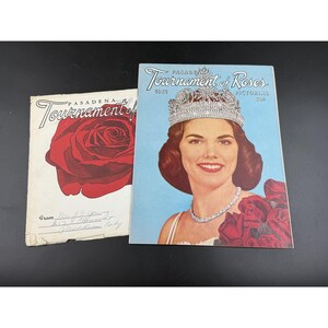 May include: Two vintage Pasadena Tournament of Roses pictorial booklets. One features a large red rose illustration with handwritten text at the bottom. The other shows a woman wearing a crown and necklace with red roses on a light blue background.