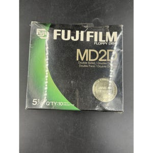 May include: A box of Fuji Film MD2D 5 1/4 inch floppy disks. The box is black with green and white accents. The text "FUJI FILM" and "MD2D" are prominently displayed. The box contains 10 disks.