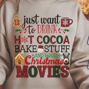 Könnte beinhalten: Beiges Sweatshirt mit dem Text "just want to DRINK HOT COCOA BAKE STUFF AND WATCH Christmas MOVIES" in Rot, Grün und Schwarz. Das Design umfasst Lebkuchenmänner, Schneeflocken und eine Tasse.