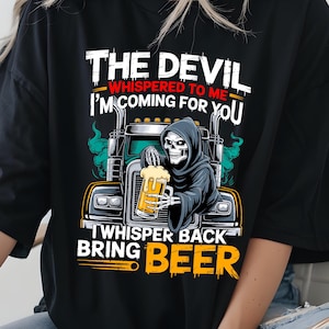 Puede incluir: Camiseta negra con un diseño de la Parca conduciendo un camión y sosteniendo una cerveza. El texto dice "THE DEVIL WHISPERED TO ME I'M COMING FOR YOU" y "WHISPER BACK BRING BEER".