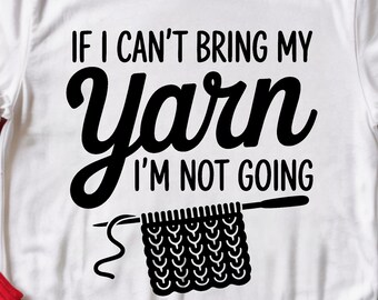 Może przedstawiać: Biała koszulka z czarnym napisem "IF I CAN'T BRING MY Yarn I'M NOT GOING". Projekt zawiera drut do robienia na drutach i kwadratowy ścieg. Koszulka jest prezentowana na czerwonym swetrze i niebieskich dżinsach.